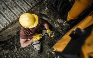 Man applying grease to machinery