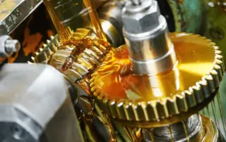 Gear oil being applied to machinery equipment to decrease viscosity and lubricate moving parts.