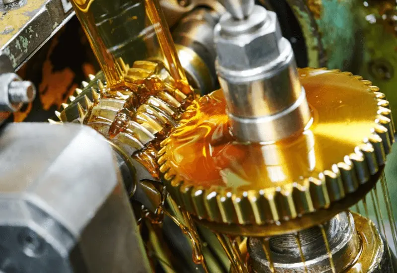 Gear oil being applied to machinery equipment to decrease viscosity and lubricate moving parts.
