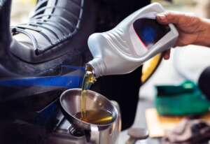 Industrial lubricants being poured into a vehicle.